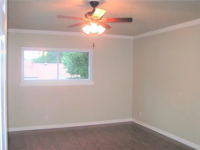 an empty room with a window and a fan