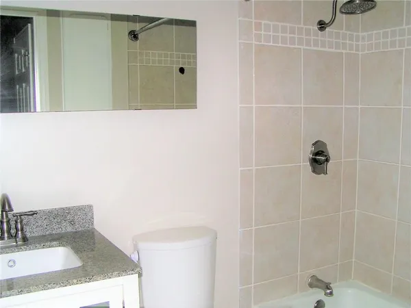 a bathroom with a granite countertop shower a sink and a mirror