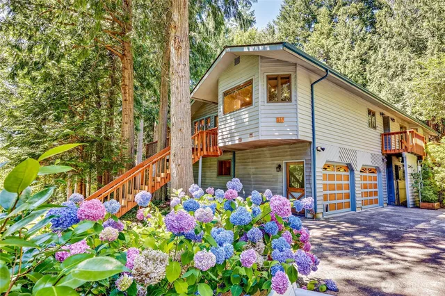 a front view of a house with lots of flowers and flowers