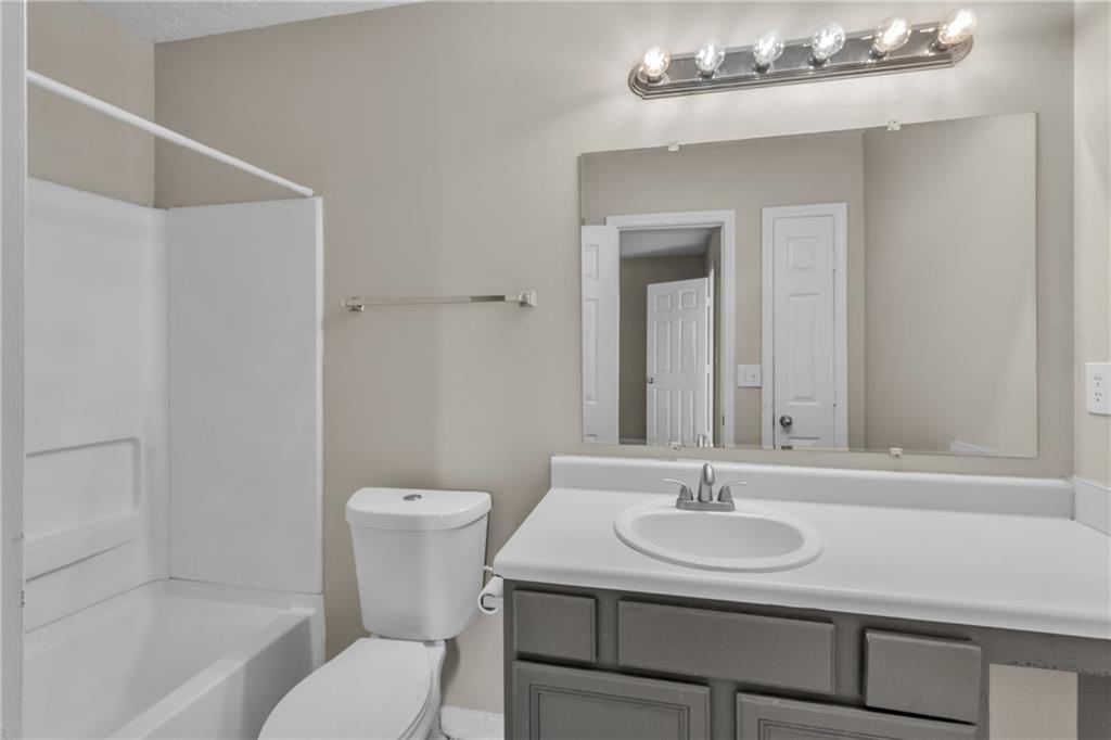 5910 Hampton Court Atlanta, GA 30349 - Photo 13 of 23 a bathroom with a sink toilet and a mirror