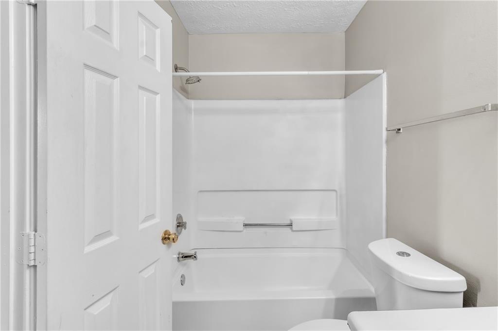 5910 Hampton Court Atlanta, GA 30349 - Photo 14 of 23 a bathroom with a bathtub and a toilet