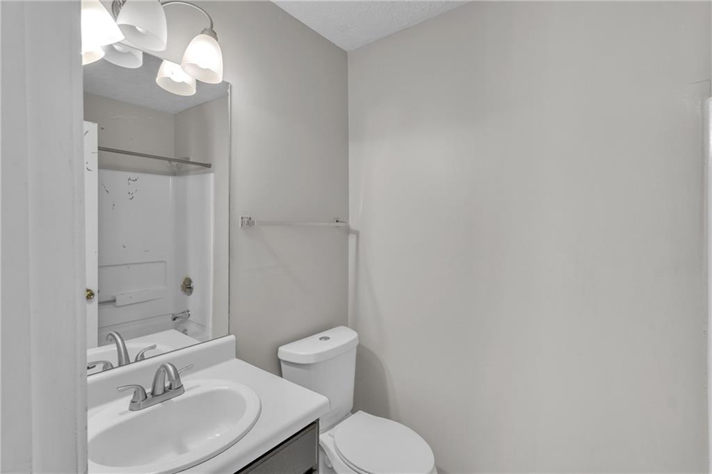5910 Hampton Court Atlanta, GA 30349 - Photo 18 of 23 a bathroom with a toilet a sink and mirror