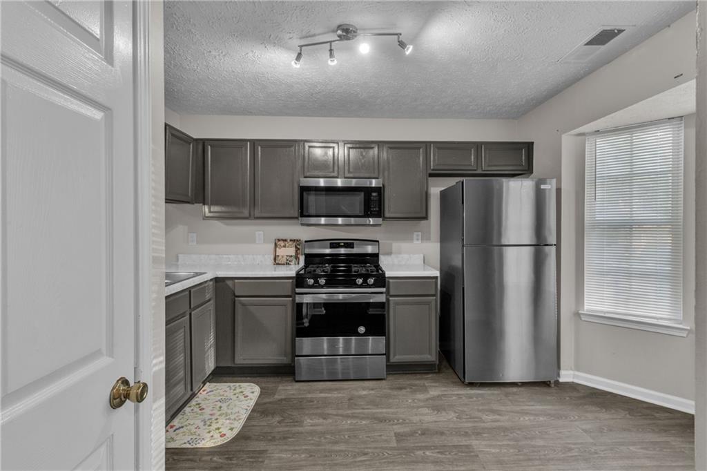 5910 Hampton Court Atlanta, GA 30349 - Photo 6 of 23 a kitchen with a refrigerator sink and wooden floor