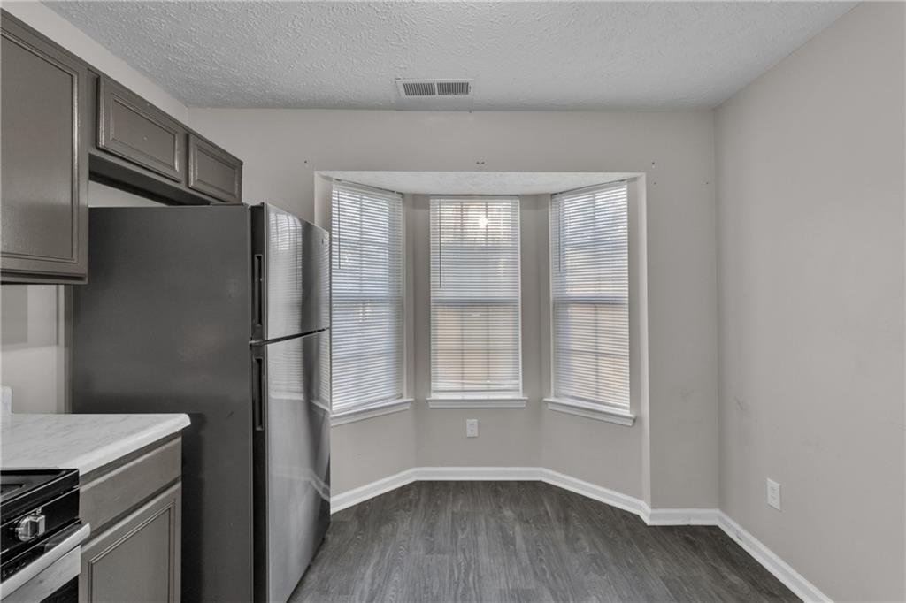 5910 Hampton Court Atlanta, GA 30349 - Photo 7 of 23 a kitchen with a refrigerator and wooden floor