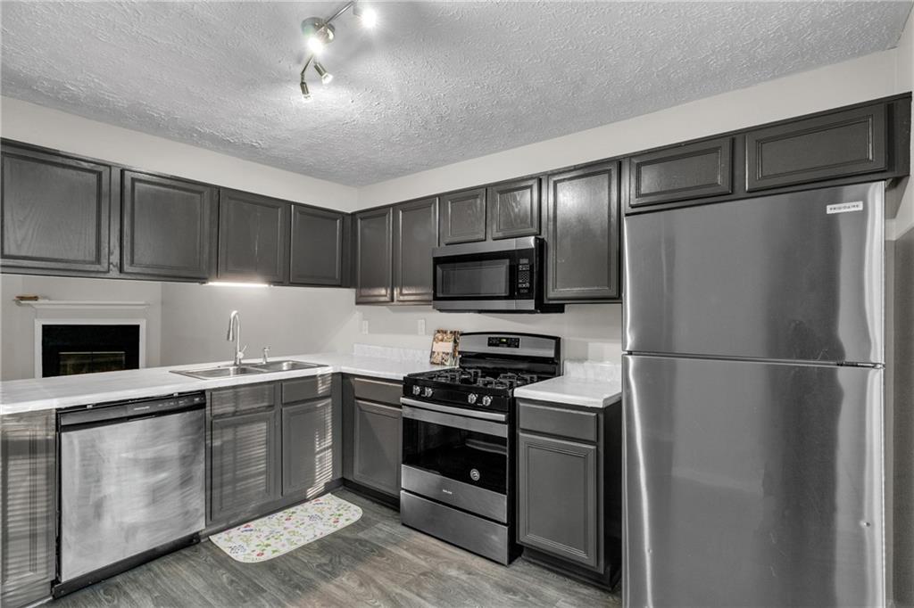 5910 Hampton Court Atlanta, GA 30349 - Photo 8 of 23 a kitchen with cabinets stainless steel appliances and a counter space
