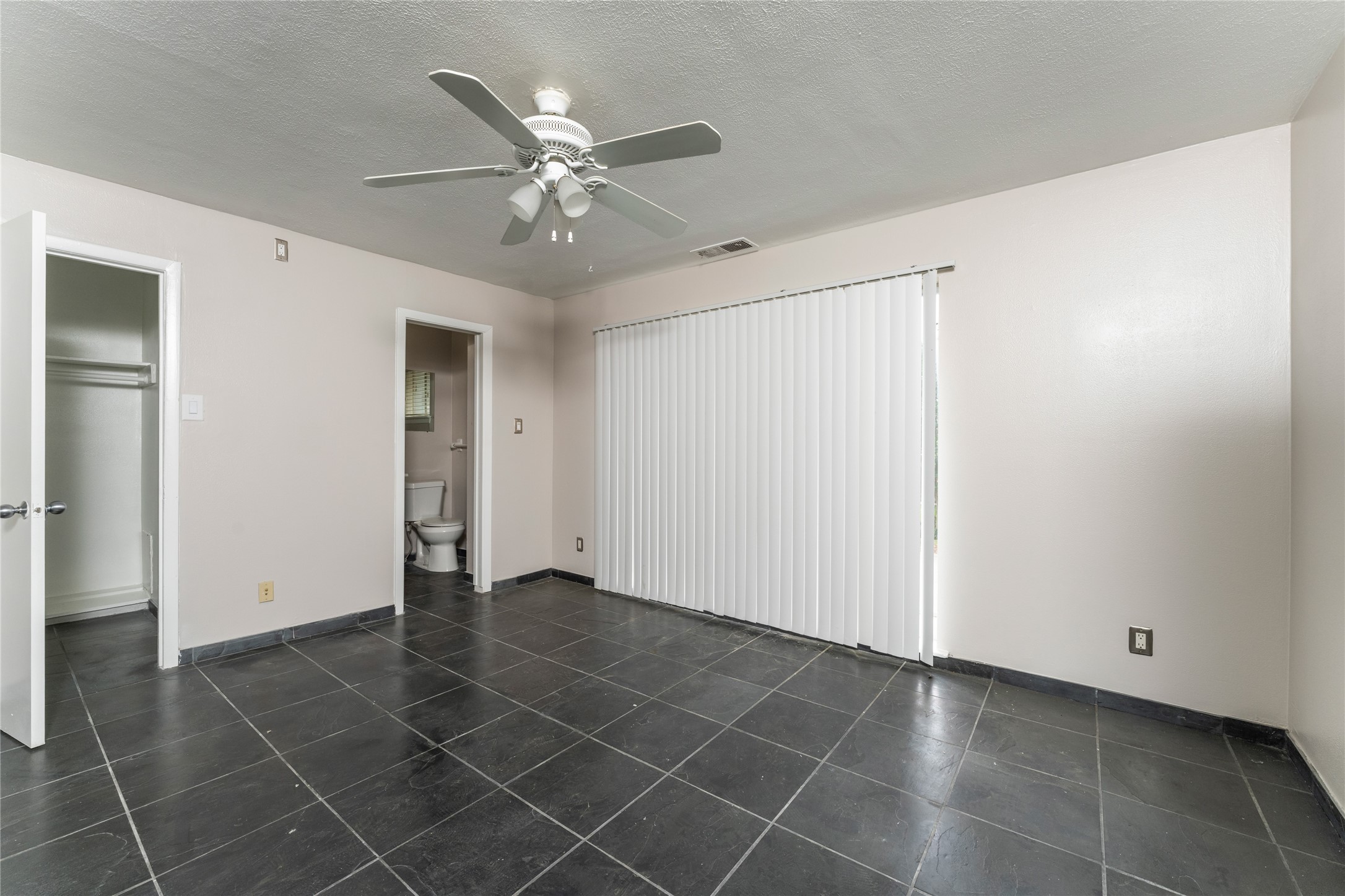 420 West Alabama Street, Unit 10 Houston, TX 77006 - Photo 3 of 9 an empty room with a ceiling fan and carpet