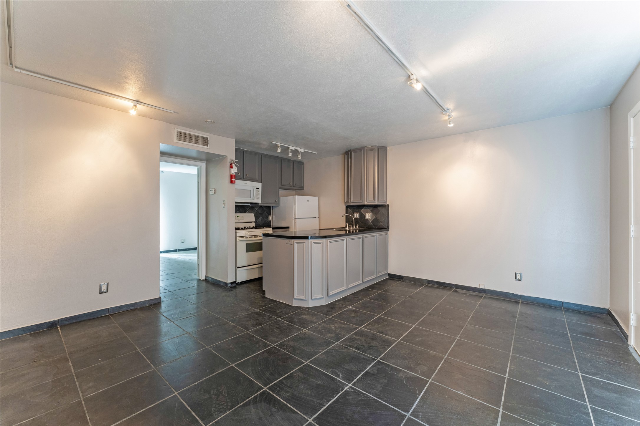 420 West Alabama Street, Unit 10 Houston, TX 77006 - Photo 5 of 9 a kitchen with stainless steel appliances a sink a stove a refrigerator and cabinets