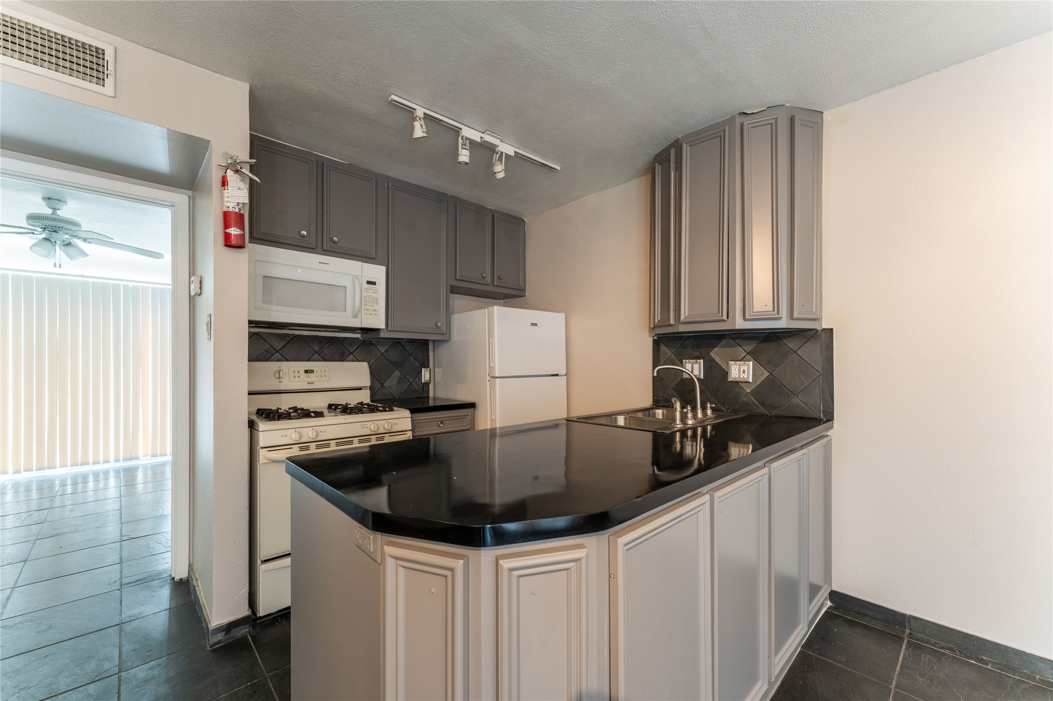 420 West Alabama Street, Unit 10 Houston, TX 77006 - Photo 7 of 9 a kitchen with stainless steel appliances a sink a stove a refrigerator and cabinets