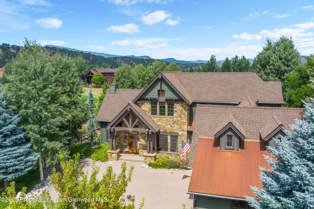 a front view of a house with a yard and potted plants