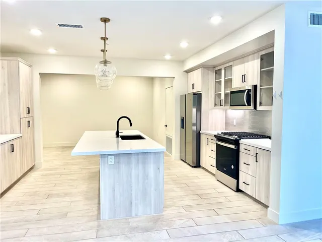 a kitchen with stainless steel appliances granite countertop a refrigerator a sink and a stove