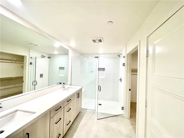a bathroom with a double vanity sink mirror double and shower