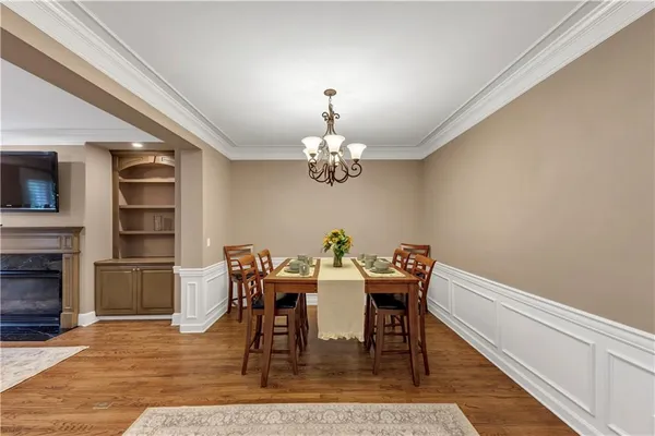 a large kitchen with stainless steel appliances kitchen island granite countertop a table chairs in it and wooden floors