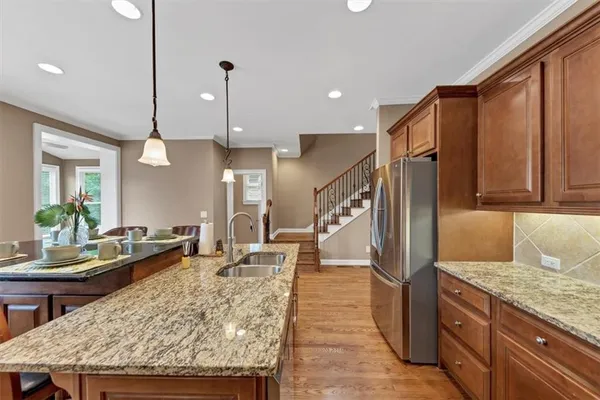 a kitchen with stainless steel appliances granite countertop a refrigerator and a stove top oven