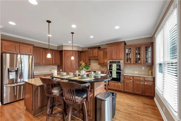 a kitchen with granite countertop a sink a counter top space appliances and cabinets
