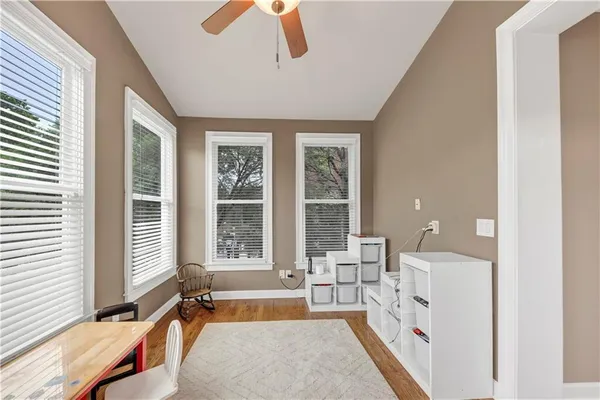 a bathroom with a granite countertop sink a toilet a mirror a lamp and shower curtain