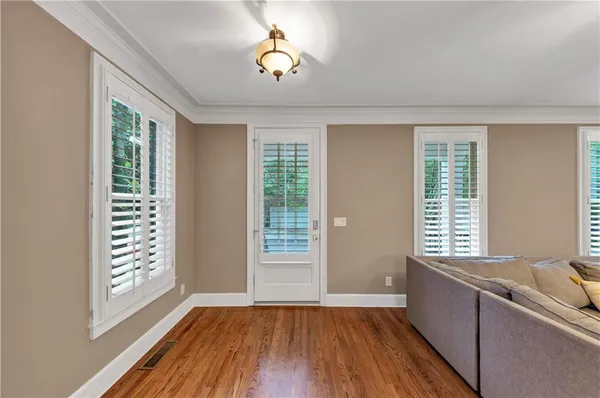 a view of an empty room with a window and wooden floor