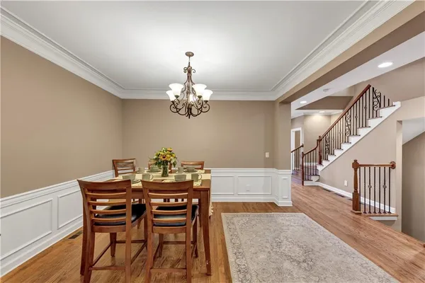 a dining room with furniture a chandelier and wooden floor