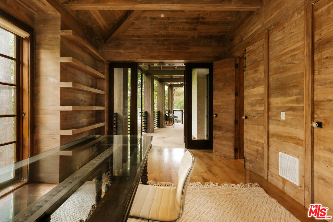 1105 Rivas Canyon Road Pacific Palisades, CA 90272 - Photo 18 of 49 a view of a hallway with wooden floor and windows