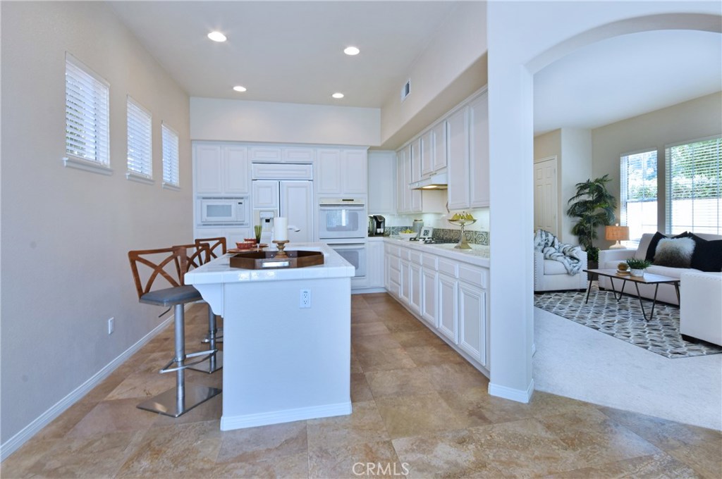 3619 Cll Joaquin Calabasas, CA 91302 - Photo 23 of 42 a kitchen with kitchen island granite countertop a table chairs sink and cabinets