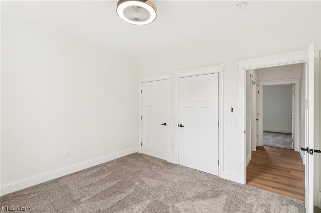 6535 North Ridge Road West Geneva, OH 44041 - Photo 24 of 48 Unfurnished bedroom featuring light colored carpet and multiple closets