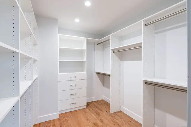 a view of walk in closet with empty racks