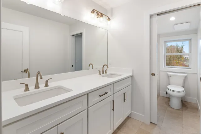a bathroom with a toilet sink and mirror
