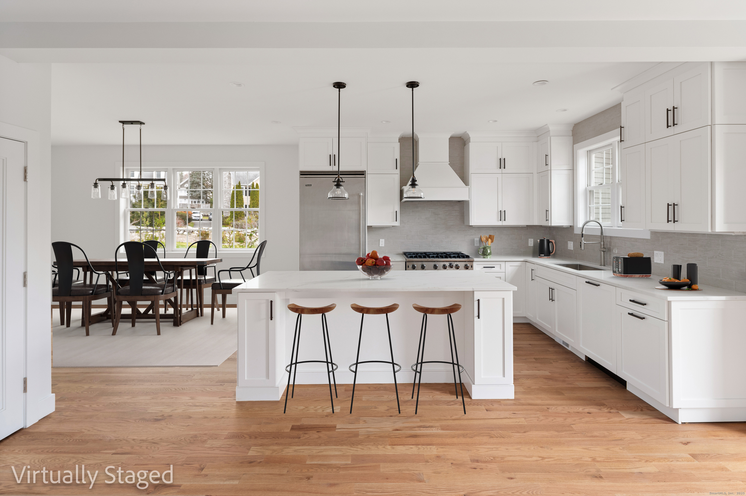 12 Walnut Ridge Court Stamford, CT 06905 - Photo 7 of 32 a kitchen with stainless steel appliances kitchen island granite countertop a table chairs stove and white cabinets