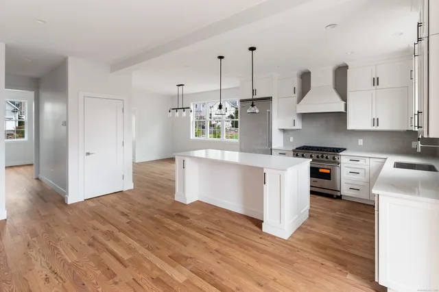 a kitchen with stainless steel appliances granite countertop a stove a sink and a refrigerator