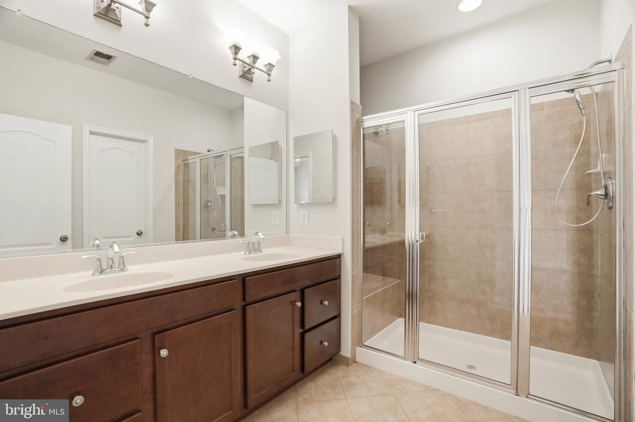 9817 Solar Course Laurel, MD 20723 - Photo 18 of 59 a bathroom with a double vanity sink mirror and shower