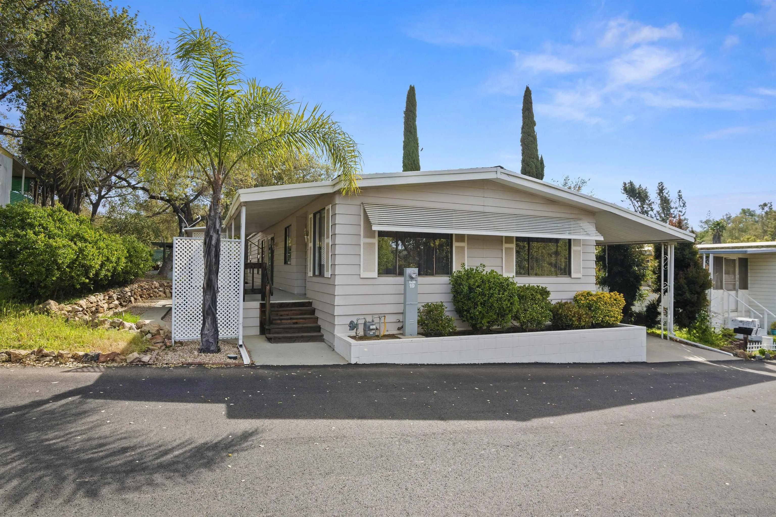 4747 Oak Crest Road, Unit 19 Fallbrook, CA 92028 - Photo 10 of 53 a front view of a house with a garden and plants