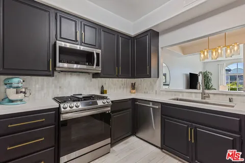 a kitchen with stainless steel appliances granite countertop stove microwave and sink