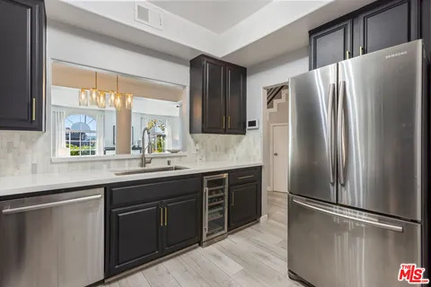 a kitchen with stainless steel appliances granite countertop a refrigerator and a sink