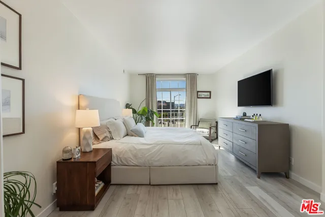 a bedroom with a bed and a flat screen tv