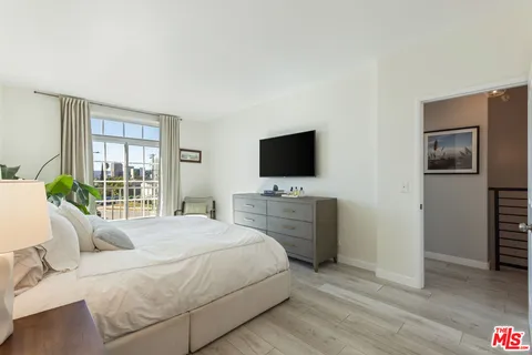 a bedroom with a bed and a flat screen tv