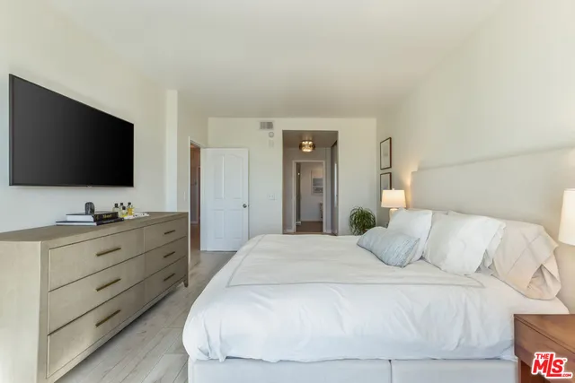 an empty room with wooden floor closet and windows