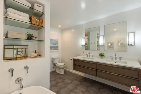 a spacious bathroom with a double vanity sink mirror and toilet