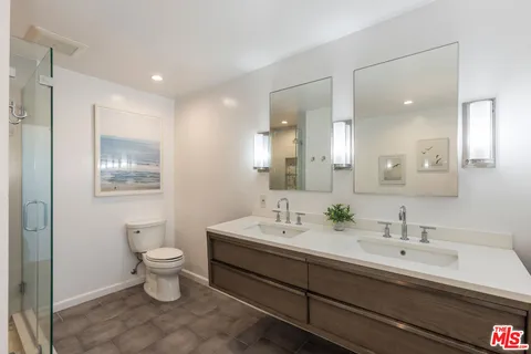 a bathroom with double sink and two mirror