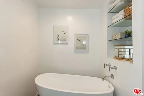 a bedroom with a large bed and a potted plant