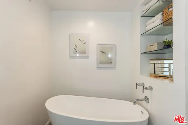 a bedroom with a large bed and a potted plant