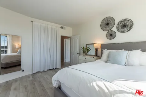 a living room with furniture potted plant and a large window