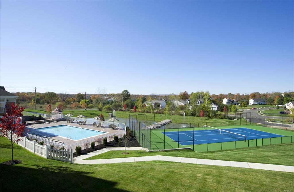 227 Tower Ridge Circle, Unit 227 Middletown, NY 10941 - Photo 13 of 16 View of tennis court featuring a lawn and a community pool
