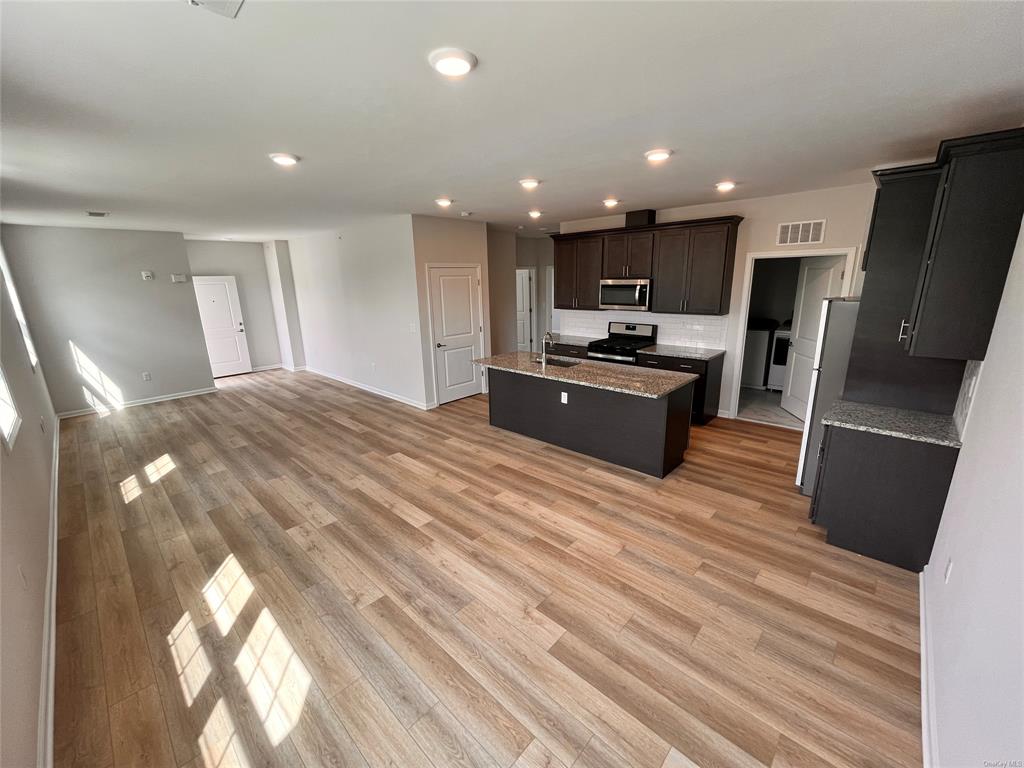 227 Tower Ridge Circle, Unit 227 Middletown, NY 10941 - Photo 2 of 16 Kitchen with sink, an island with sink, light wood-type flooring, and appliances with stainless steel finishes