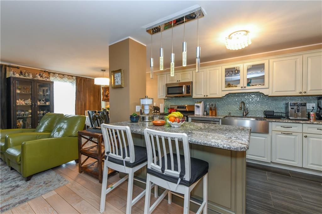 601 Surf Avenue, Unit 20J Brooklyn, NY 11224 - Photo 8 of 46 a kitchen with stainless steel appliances granite countertop a table chairs and a refrigerator