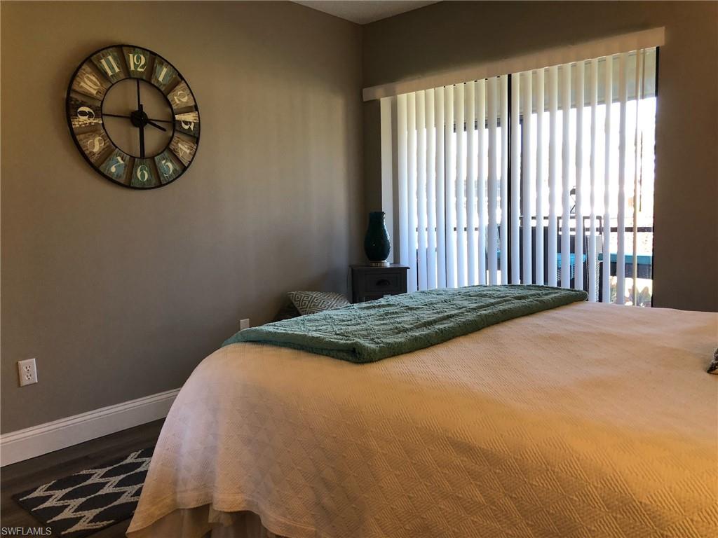 252 Pebble Beach Circle, Unit C103 Naples, FL 34113 - Photo 12 of 21 a bedroom with a bed and a window