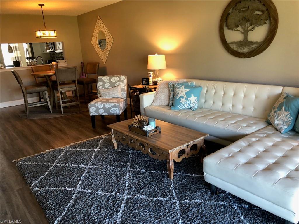 252 Pebble Beach Circle, Unit C103 Naples, FL 34113 - Photo 3 of 21 a living room with furniture and a table