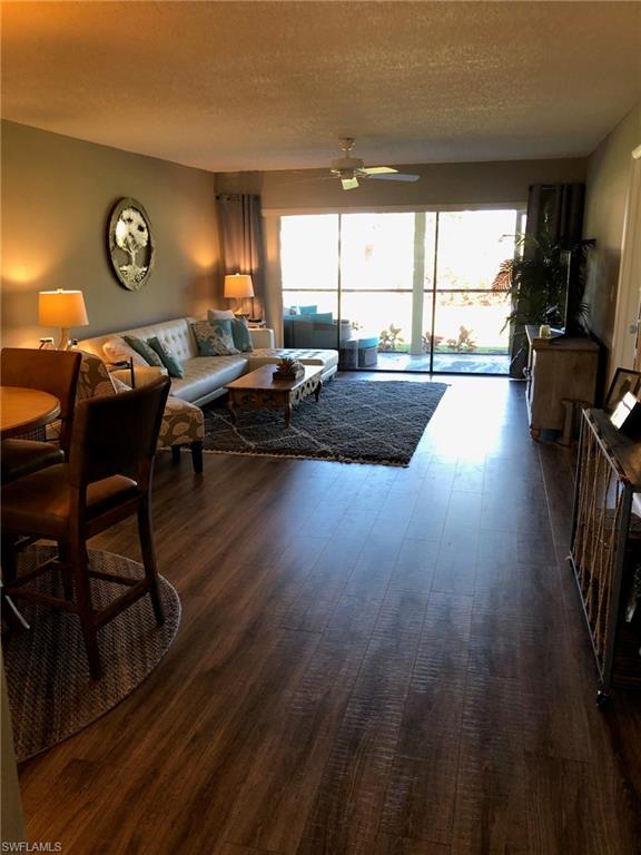 252 Pebble Beach Circle, Unit C103 Naples, FL 34113 - Photo 4 of 21 a living room with furniture and a large window