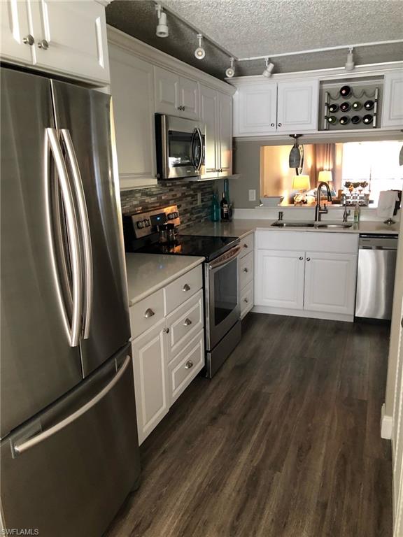 252 Pebble Beach Circle, Unit C103 Naples, FL 34113 - Photo 8 of 21 a kitchen with stainless steel appliances a refrigerator sink and microwave