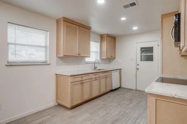 a kitchen with granite countertop white cabinets and white appliances