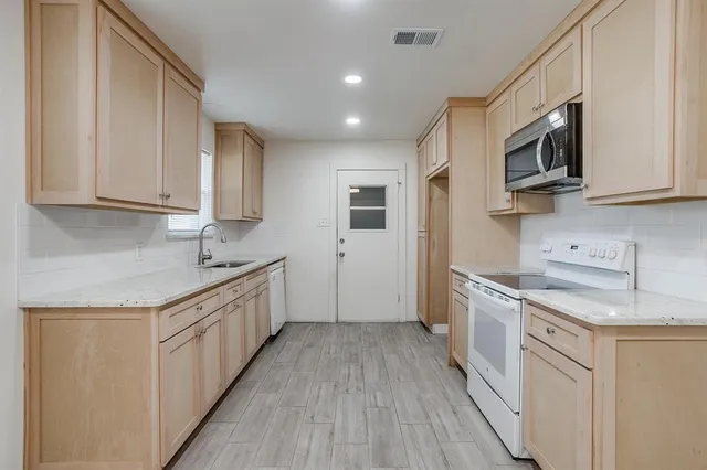 a kitchen with stainless steel appliances granite countertop a sink stove and refrigerator