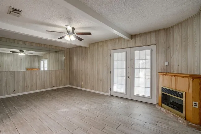 a view of an empty room with a fireplace and a window